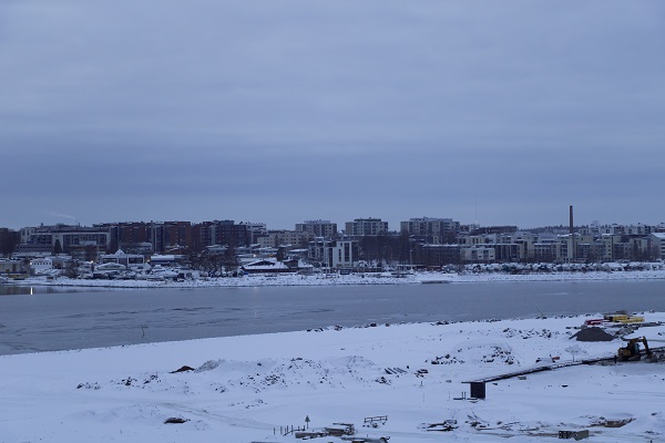 Snowy town across a body of water in the evening